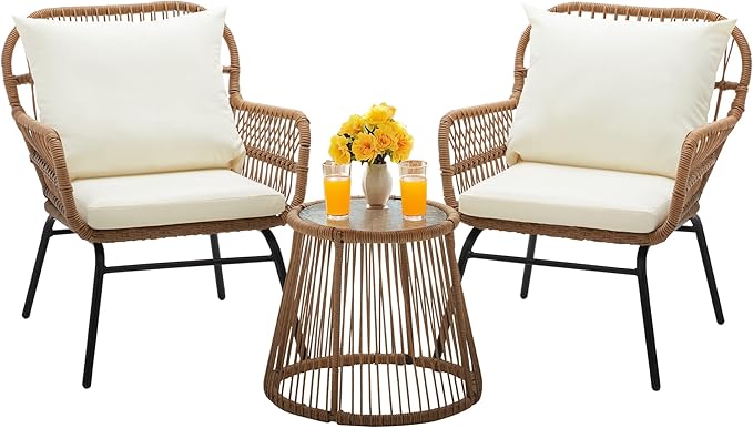 Two wicker chairs with white cushions and a matching round table on a white background