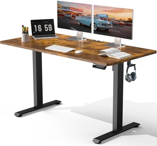 A modern standing desk with a brown wood-grain desktop and black metal legs, shown with a laptop, dual computer monitors, keyboard, mouse, headphones, and an open book on a white background.