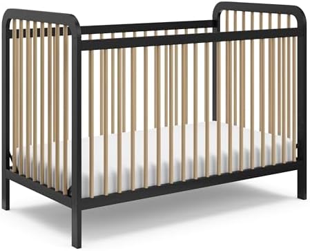 A toddler bed with a black metal frame and natural wood vertical slats, shown with a white mattress on a clean white background.