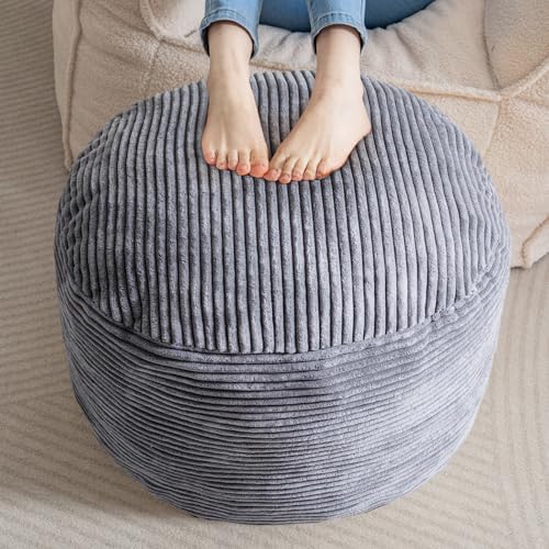 Person sitting on a textured gray ottoman with feet visible.