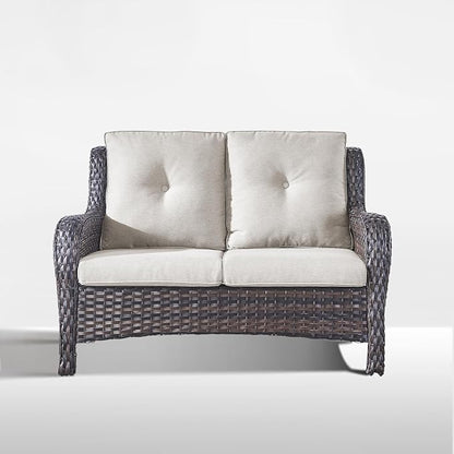 A two-seater wicker loveseat with dark gray woven frames and light beige tufted cushions, shown against a plain light gray background.
