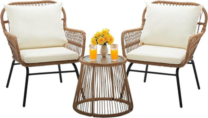 Two wicker chairs with white cushions and a matching round table on a white background