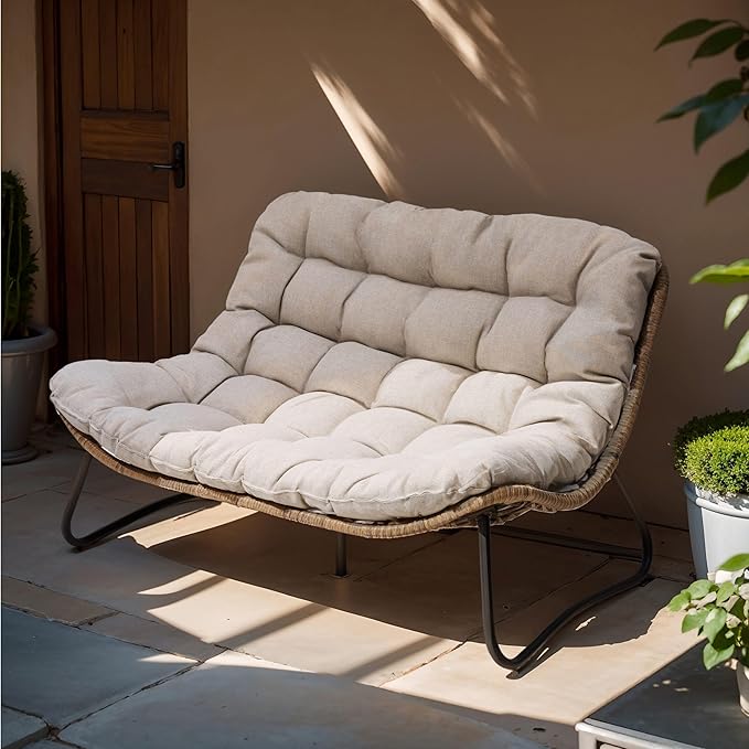 Beige cushioned chair on a patio with plants and a door in the background