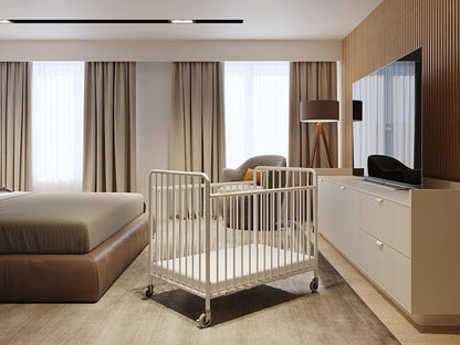 Foundations Stowaway Metal Baby & Toddler Folding Crib, Portable Baby Crib with Foam Mattress and Commercial Grade 3" Casters, Compact for Hotels, White