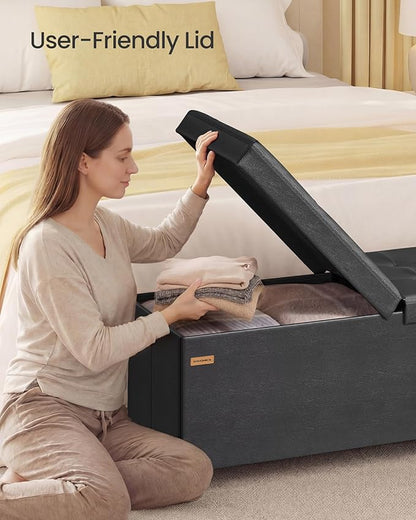SONGMICS Storage Ottoman Bench with Legs, Folding Ottoman Foot Rest with Flipping Lid, Bench with Storage, for Living Room, Bedroom, Entryway, Synthetic Leather, 43.3 Inches, Ink Black ULSF085BH01
