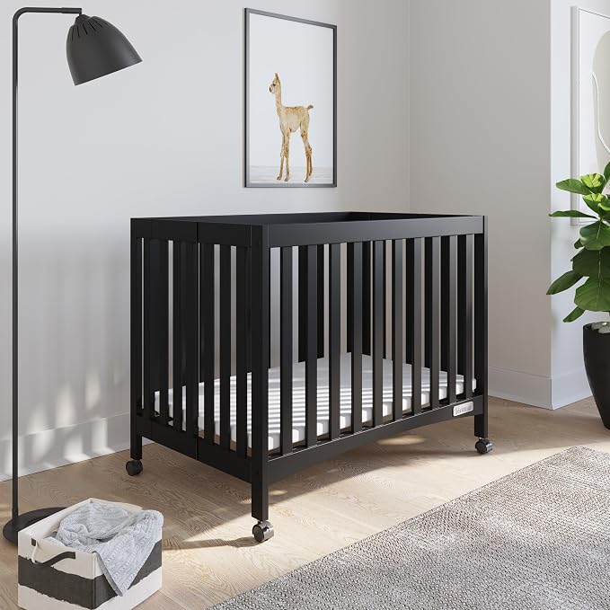 Child Craft London Mini Compact Folding Portable Crib with 2” Crib Mattress and 2 Easy Roll Locking Wheels, Durable Pine Wood Construction (Ebony Black)