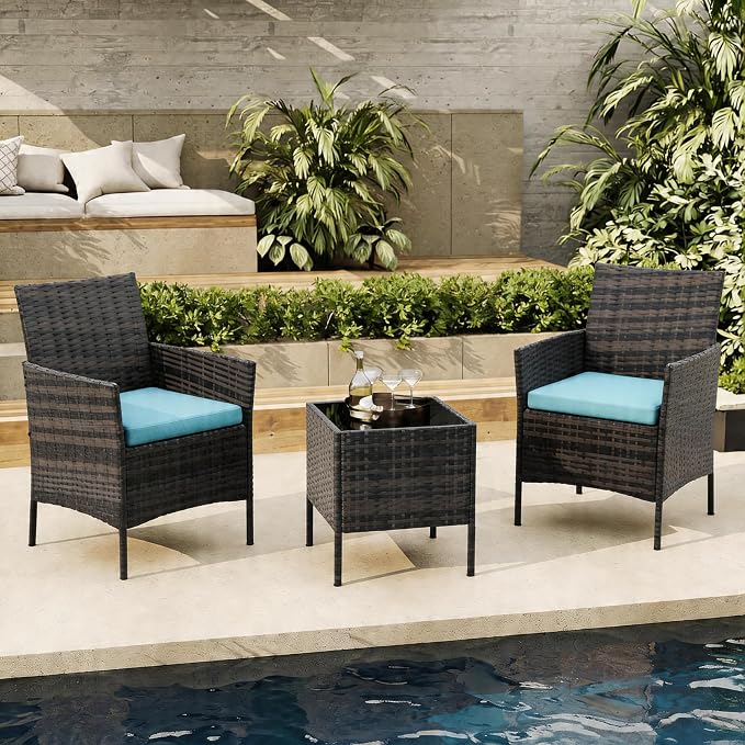 Outdoor patio set with two chairs and a table by a poolside.
