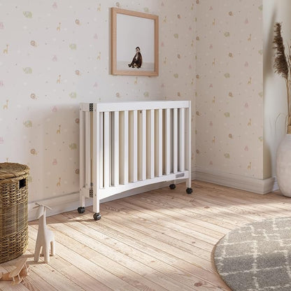 Child Craft London Mini Compact Folding Portable Crib with 2” Crib Mattress and 2 Easy Roll Locking Wheels, Durable Pine Wood Construction (Matte White)